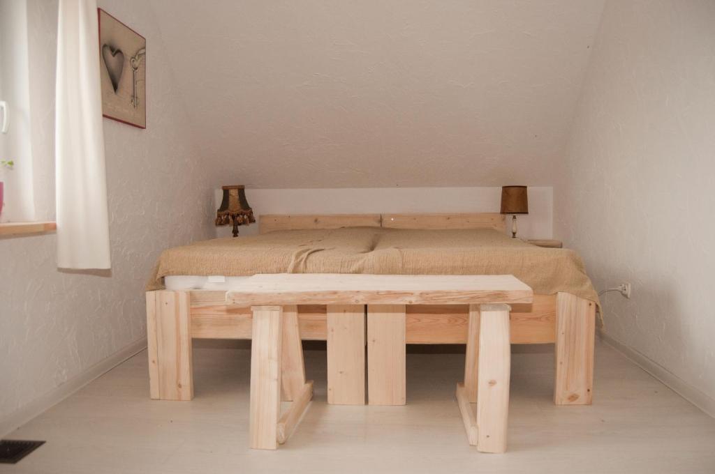 1 dormitorio con cama y mesa de madera en Domek Masuria, en Orzysz