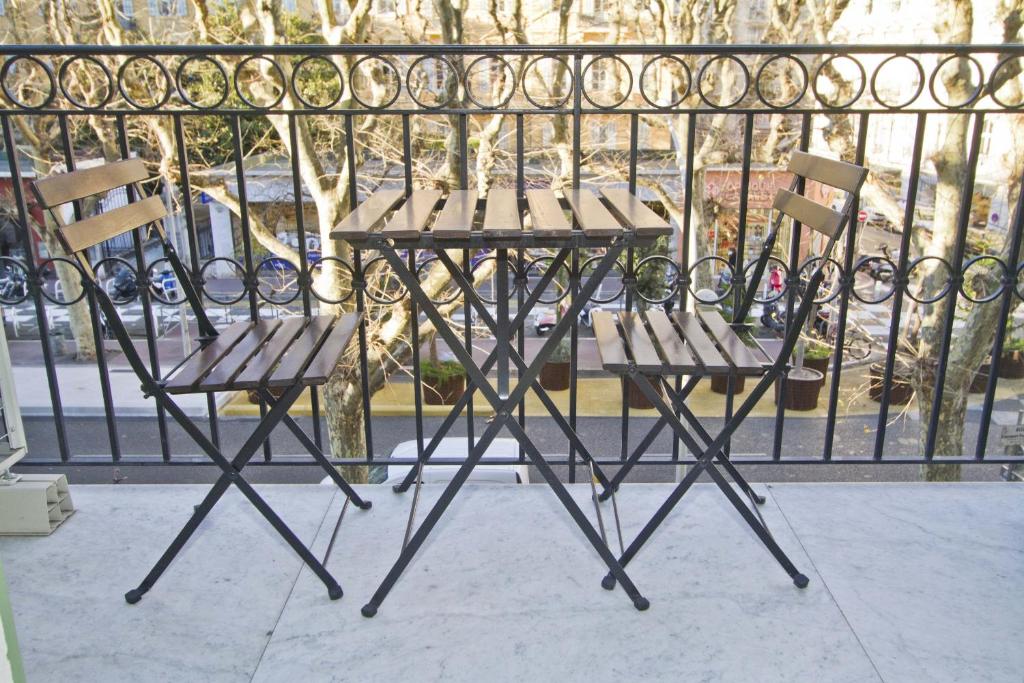 2 stoelen en een tafel op een balkon bij PROMENADE HOLIDAY - GRIMALDI CITY CENTER in Nice