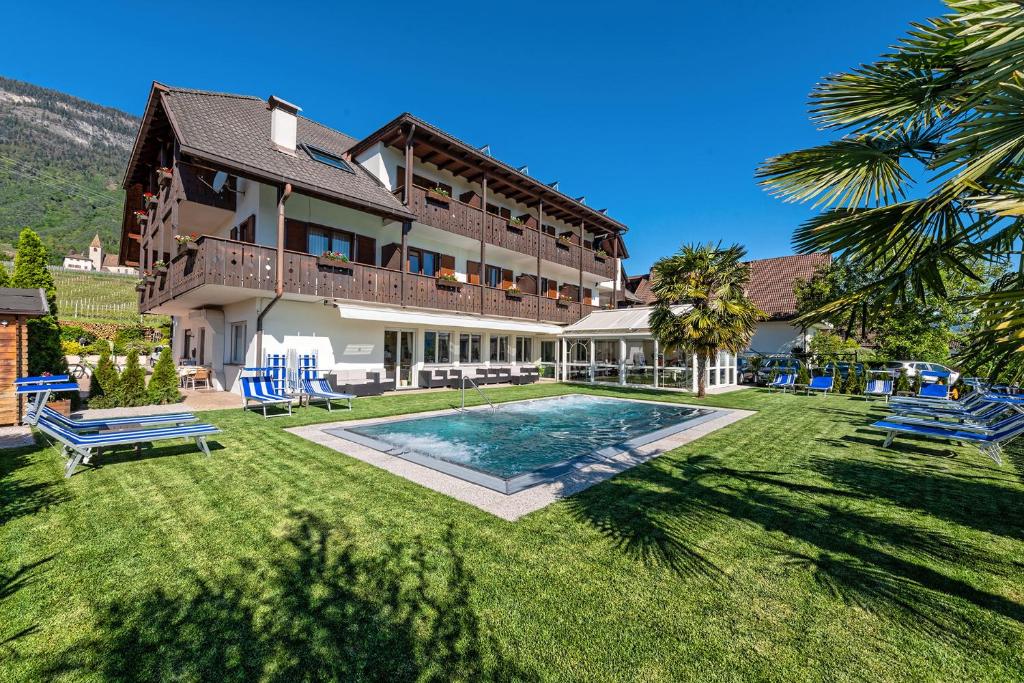 a large house with a swimming pool in the yard at Hotel St. Justina Hof in Appiano sulla Strada del Vino