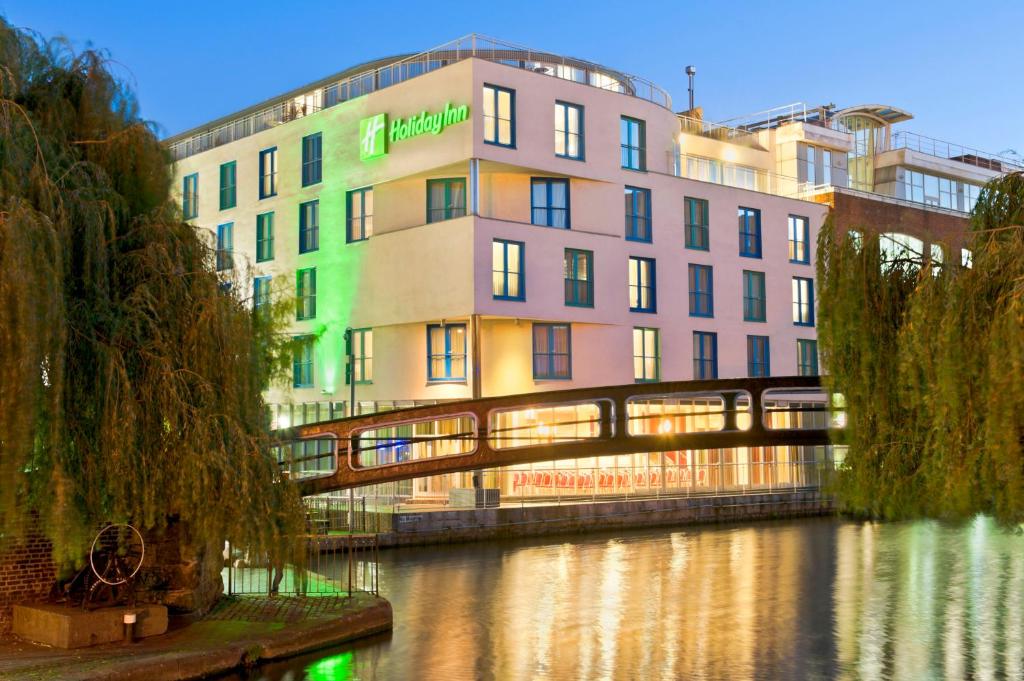 um edifício junto a um rio com uma ponte em Holiday Inn London Camden Lock, an IHG Hotel em Londres