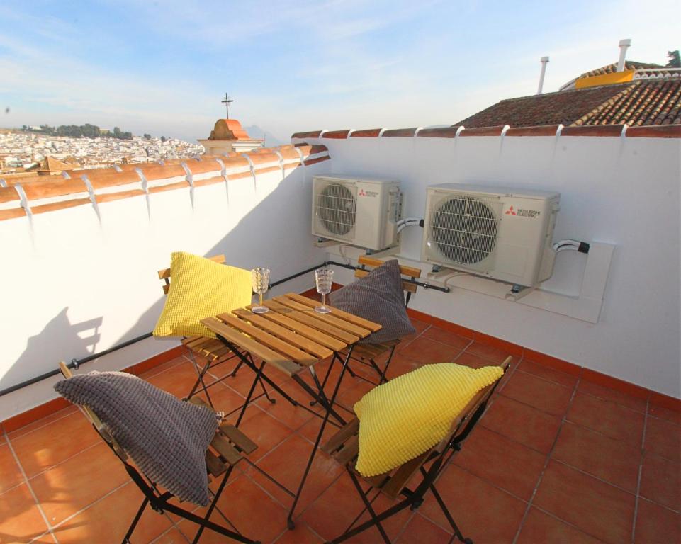 balkon ze stołem i krzesłami na dachu w obiekcie Casa Puerta de la Alcazaba Antequera w mieście Antequera