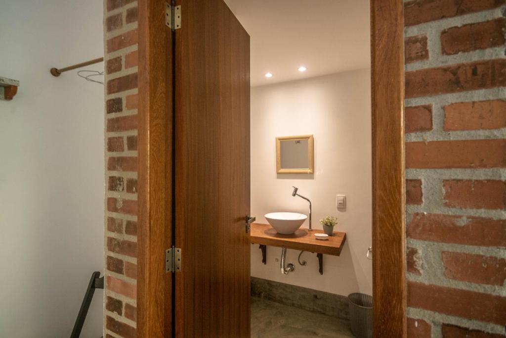 
a bathroom with a wooden wall and a wooden door at Casa Flor Paquetá in Paqueta
