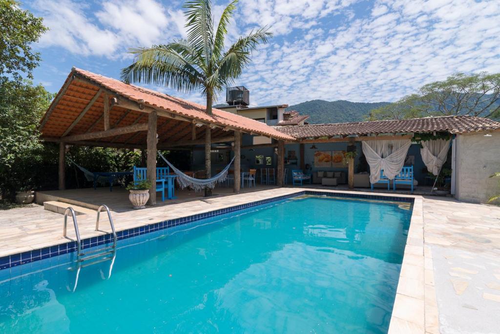 a swimming pool in front of a house at Mandala Maresias in Maresias