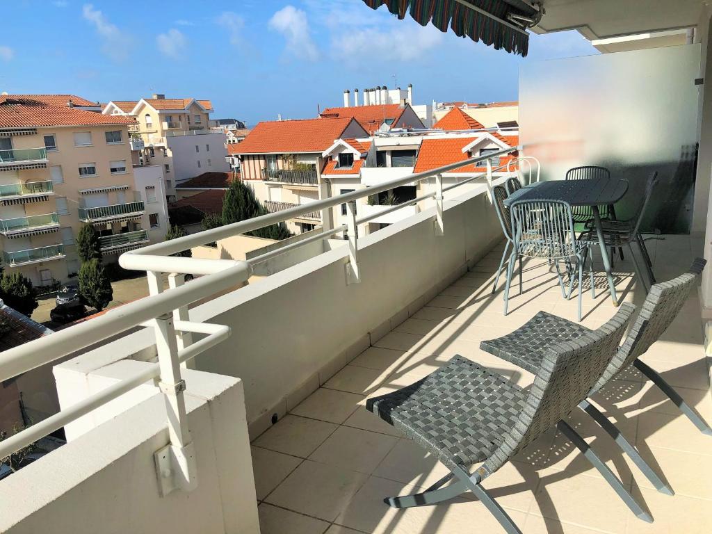 un balcon avec des chaises et des tables sur un immeuble dans l'établissement PALMA T3 confort parking centre, à Arcachon