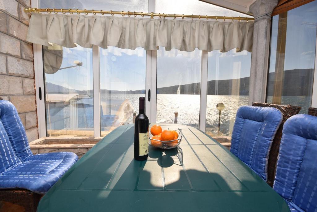 SeaSide House في هرسك نوفي: زجاجة من النبيذ موضوعة على طاولة مع وعاء من الفواكه