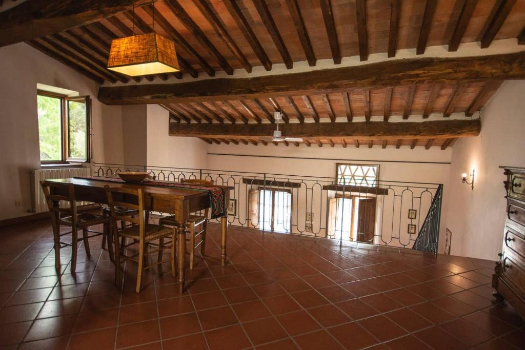 una sala da pranzo con tavolo e sedie in una casa di Agriturismo Buondonno a Castellina in Chianti