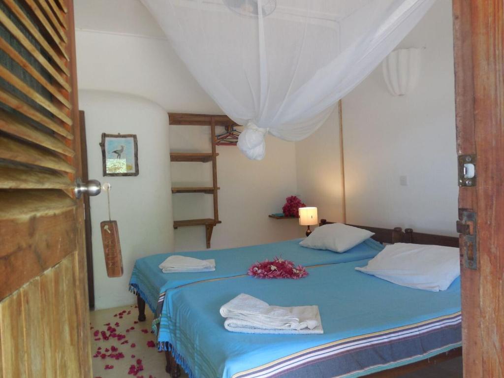 a bedroom with a blue bed and a ladder at A Rocha Eco-Lodge & Conservation Centre in Watamu