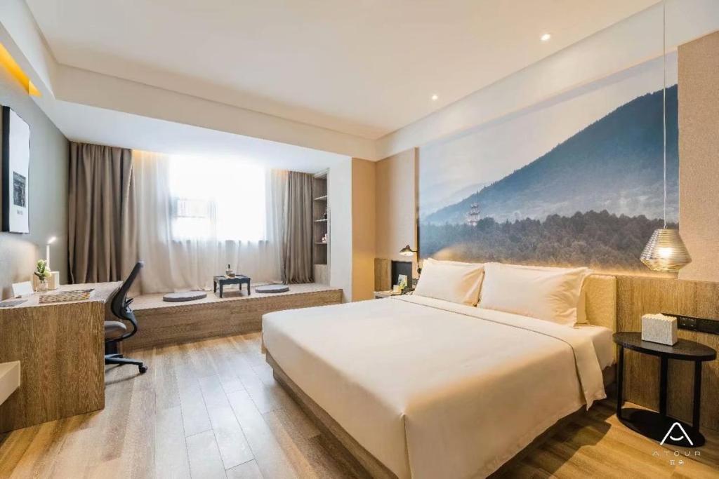 una camera d'albergo con un letto grande e una scrivania di Atour Hotel Hangzhou Qianjiang New Town Qingchun Plaza a Hangzhou