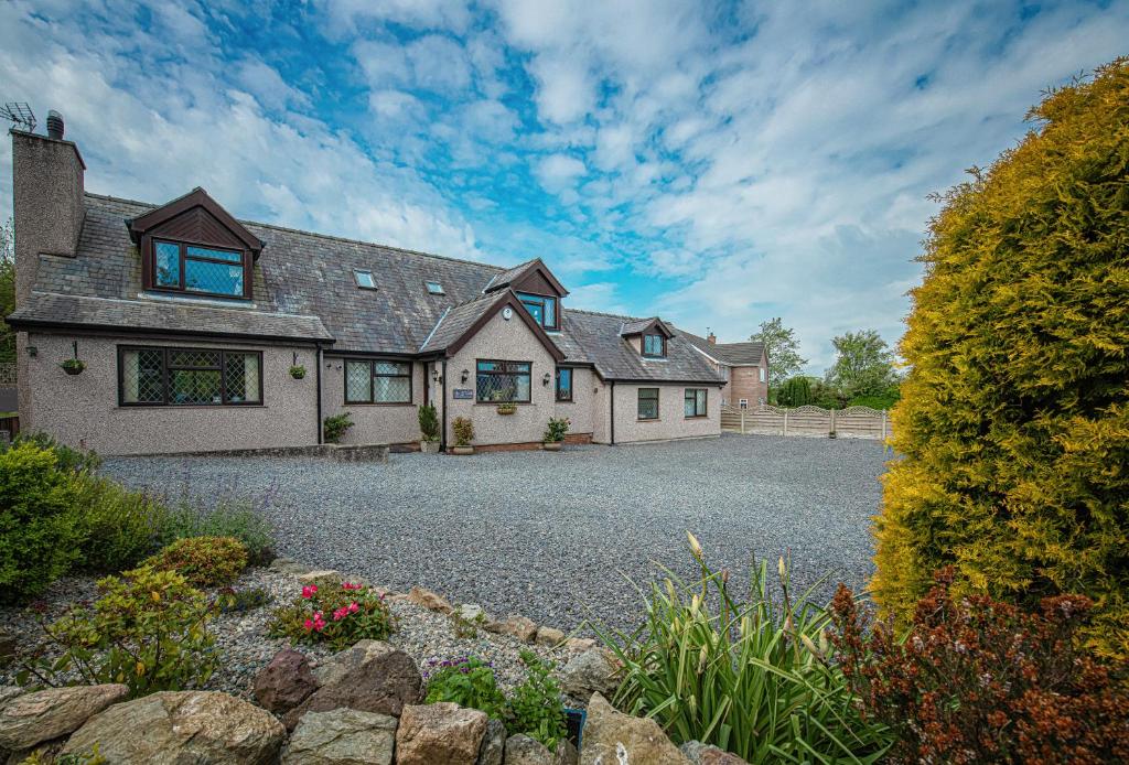 a large house with a gravel driveway at Lon y Traeth Bed & Breakfast in Pentraeth