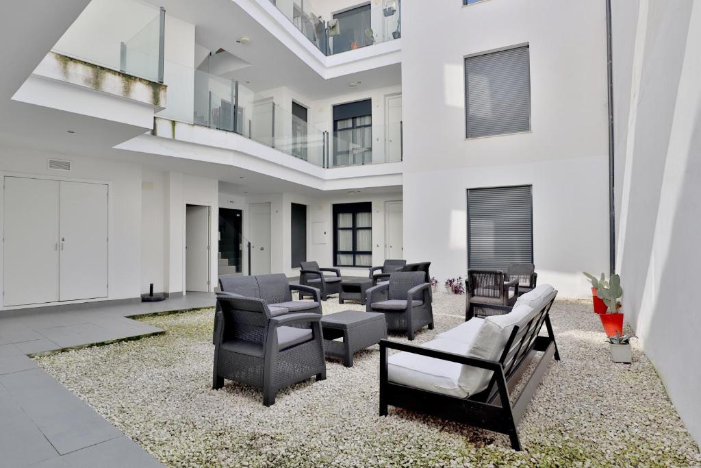 una sala de estar con sillas y mesas en un edificio en Apartamentos Centro Cordoba, en Córdoba