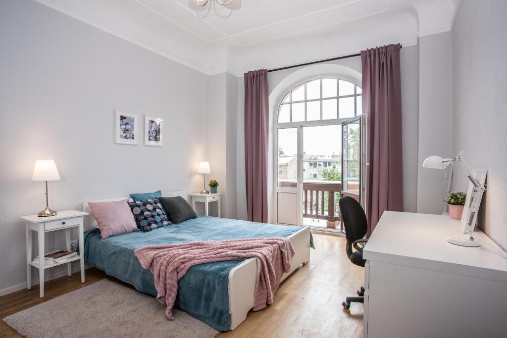 1 dormitorio con cama, escritorio y ventana en Gertrude's Residence, en Riga
