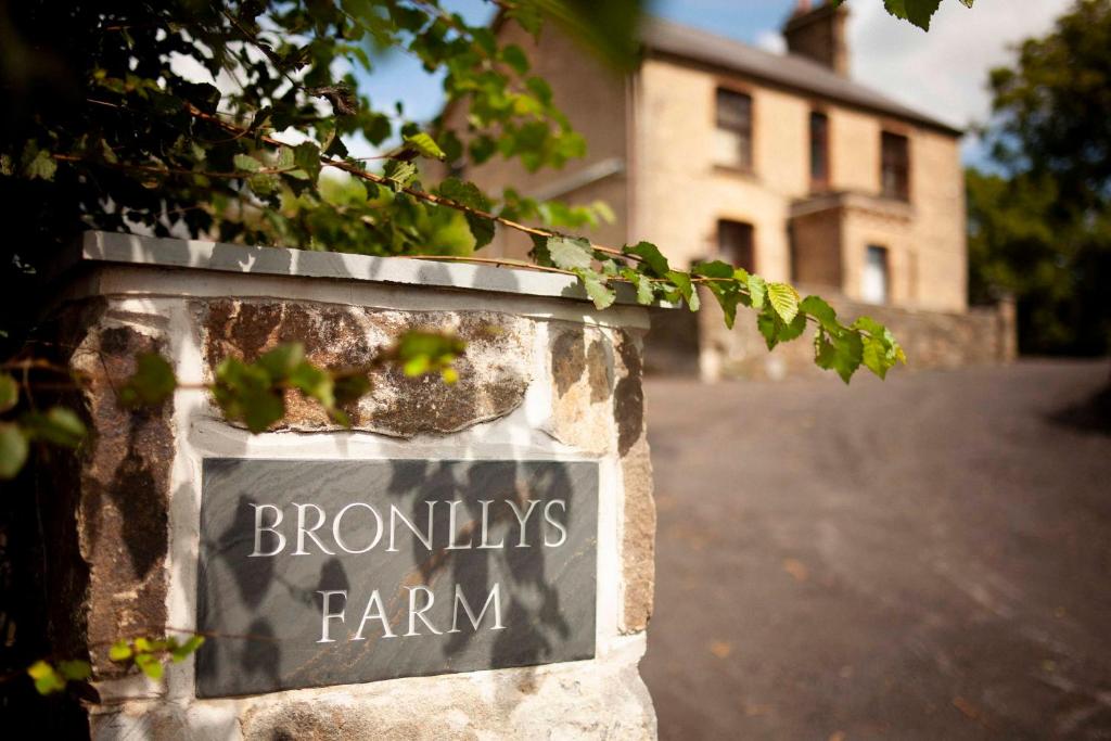 a sign that says brontneys farm in front of a house at Bronllys Farm Coastal Self-Catering in Llanelli