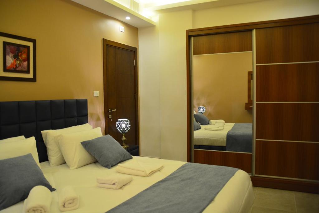 سما عمان للشقق الفندقية Sama Amman Hotel Apartments في عمّان: غرفة نوم بسرير ومرآة كبيرة