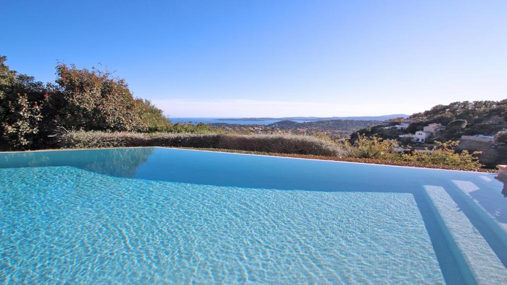 - une piscine bleue avec vue sur l'océan dans l'établissement Villa Scénic Golf, à Sainte-Maxime