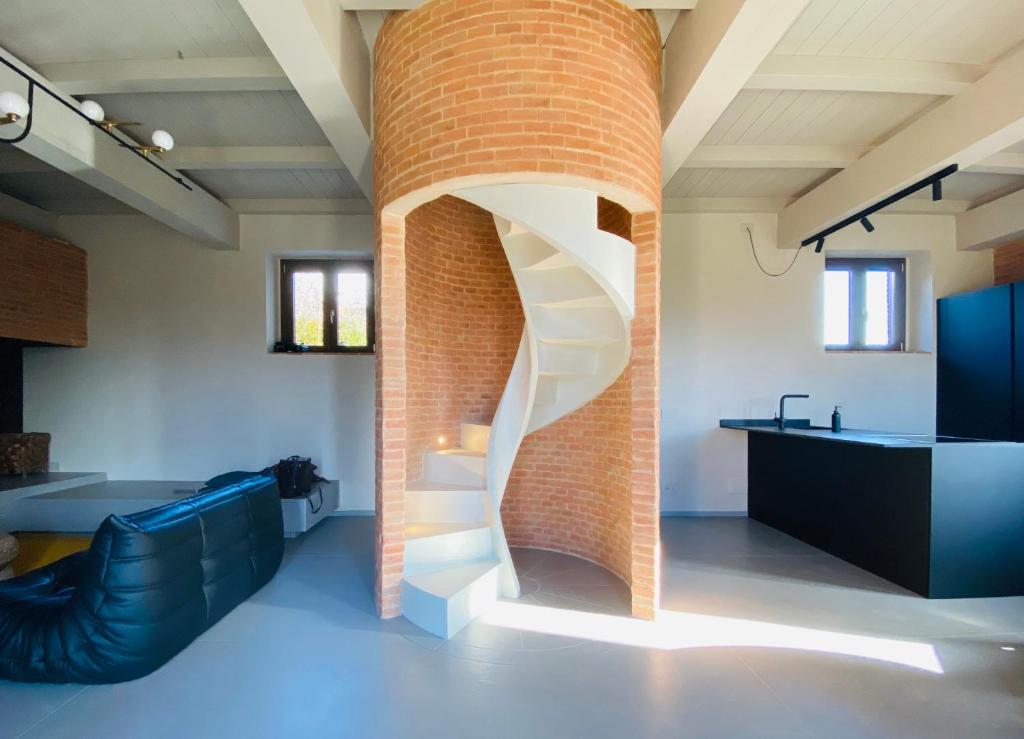 a brick wall with a spiral staircase in a room at Agriturismo PURO in Barga