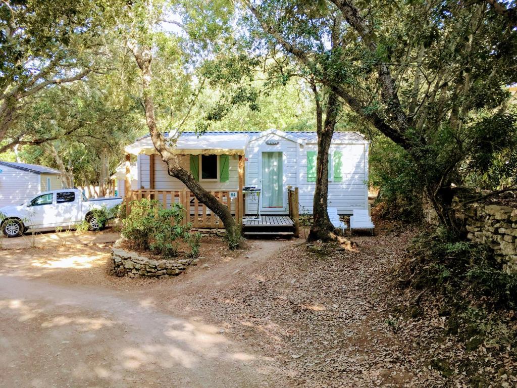 ein winziges Haus mit einer Veranda im Wald in der Unterkunft Camping Campo Di Liccia - Maeva in Bonifacio