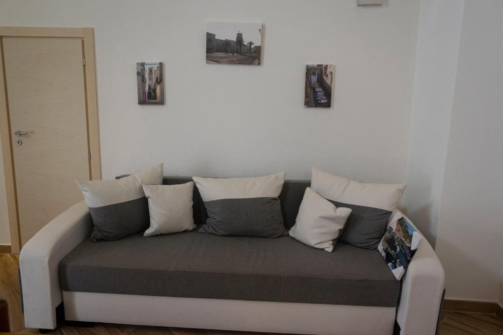 un sofá sentado en una habitación con almohadas en La Strittula Salentina, en Poggiardo