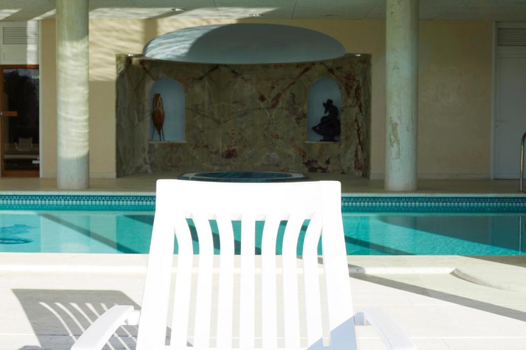 una silla blanca sentada junto a una piscina en La Mama en El Gurb
