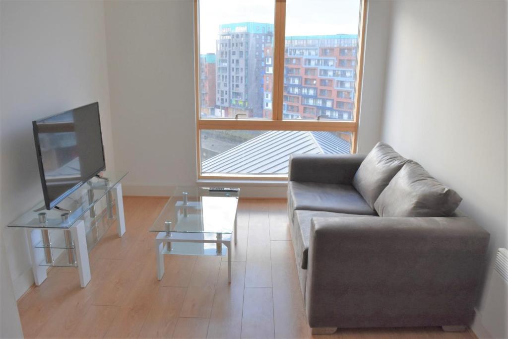 a living room with a couch and a tv at Toothbrush Apartments - Ipswich Waterfront - Quayside in Ipswich