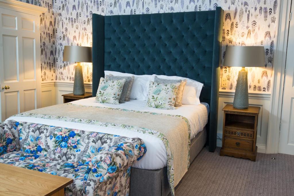 a bedroom with a large bed with a blue headboard at Judge's Lodging in York
