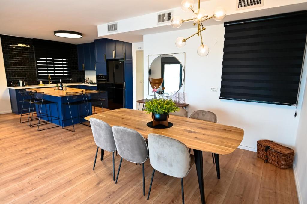uma cozinha e sala de jantar com uma mesa de madeira e cadeiras em Royal Serenity Penthouse em Tiberias