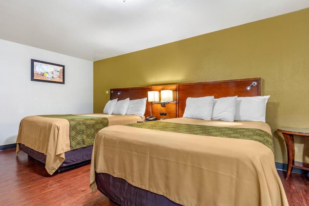 Postel nebo postele na pokoji v ubytování Rose City Inn & Suites