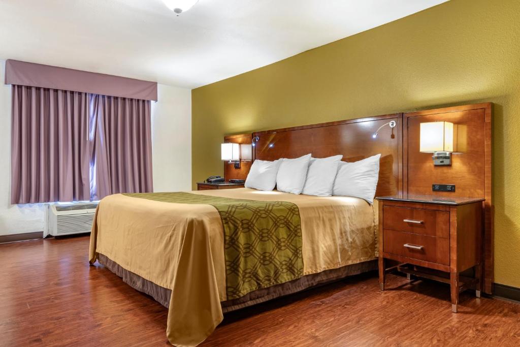 Postel nebo postele na pokoji v ubytování Rose City Inn & Suites