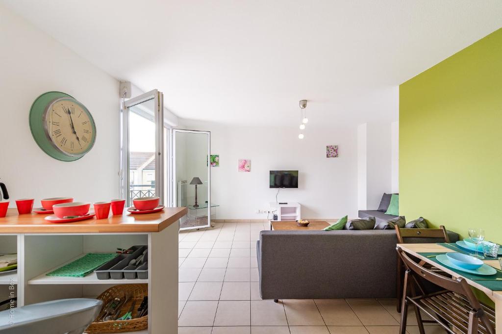 un salon avec un canapé et une horloge au mur dans l'établissement Amazing Cocoon, à Bussy-Saint-Georges