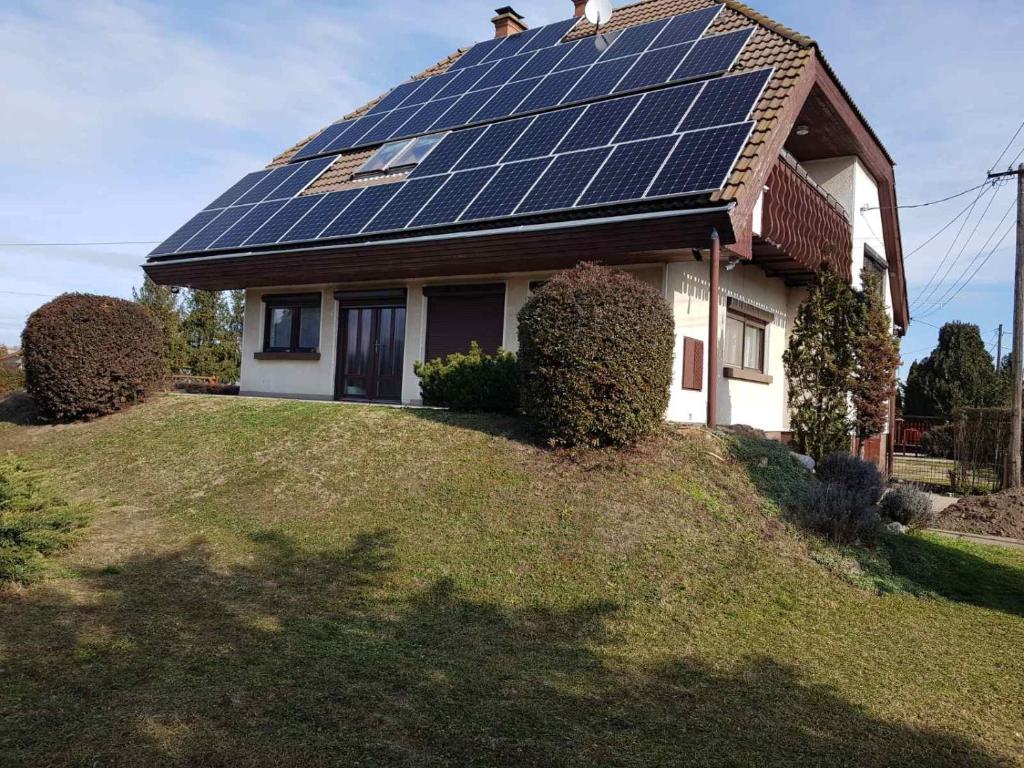 una casa con paneles solares en el techo en Vándor Szálló, en Kecskemét