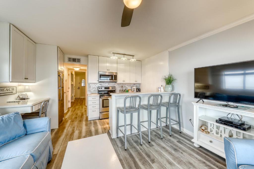 a living room with a blue couch and a kitchen at Sea Cabin 347-C in Isle of Palms