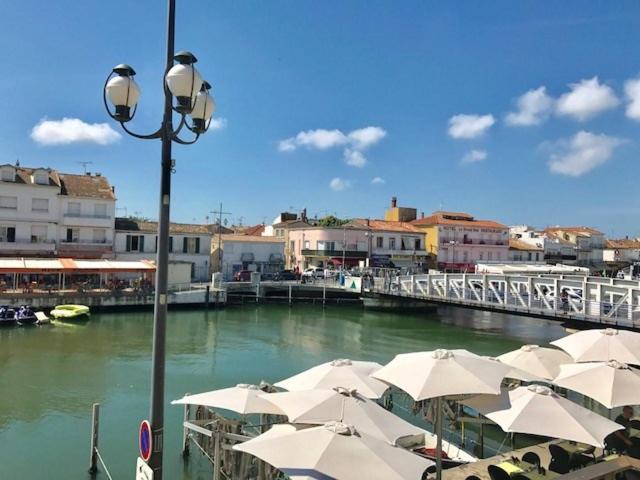 un groupe de tables avec parasols à côté d'une rivière dans l'établissement AS13871 - P2 en duplex au Centre Ville avec magnifique vue, au Grau-du-Roi