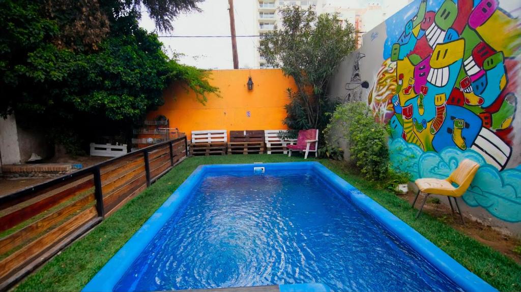 una piscina en el patio trasero de un edificio con un mural en Hostel Punto Patagonico en Neuquén