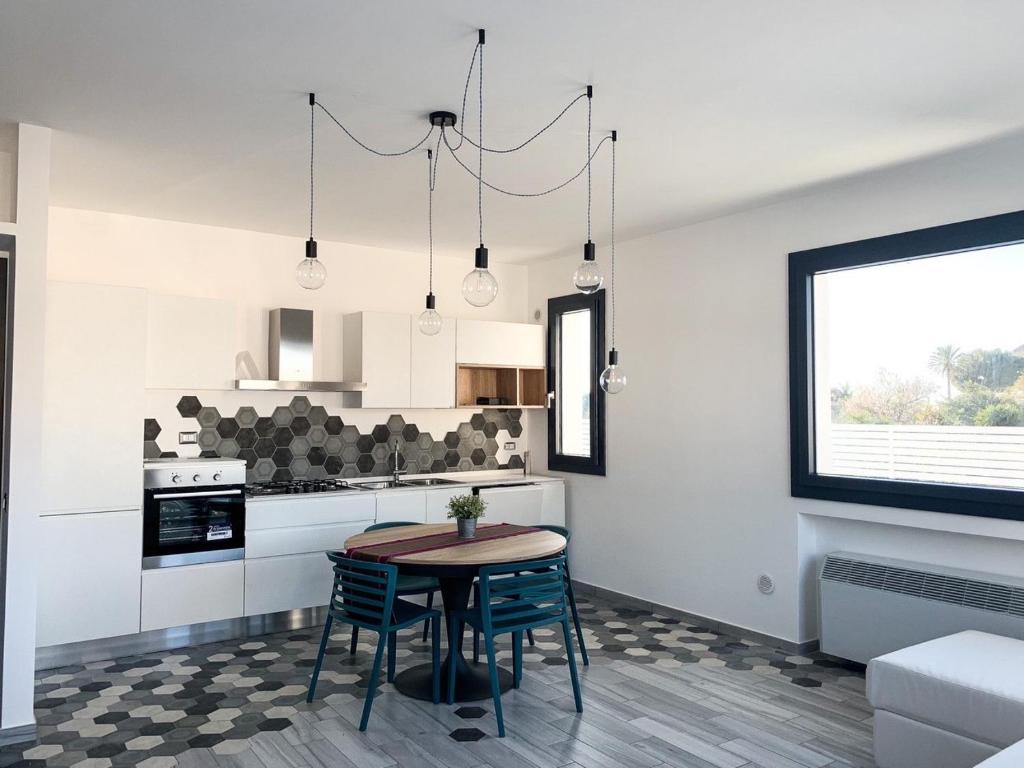 a kitchen with a table and chairs in a room at Rosalia Homestay - Levante Apartment in Cinisi