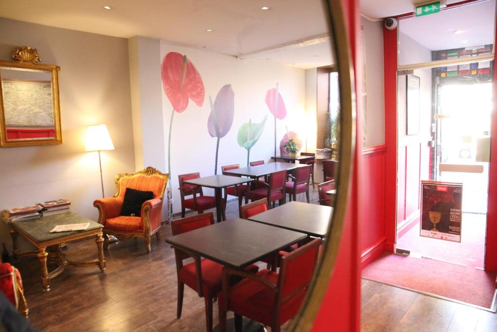 un ristorante con tavoli e sedie in una stanza di Arnaud Bernard Hôtel a Tolosa