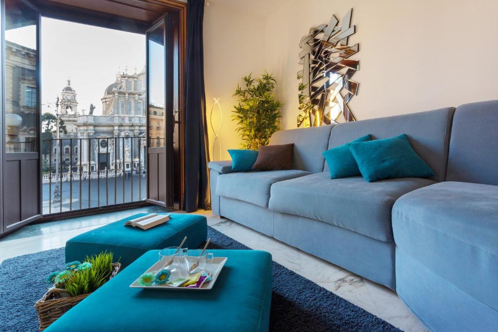 un soggiorno con divano e tavolo di Le Suites Del Duomo House a Catania