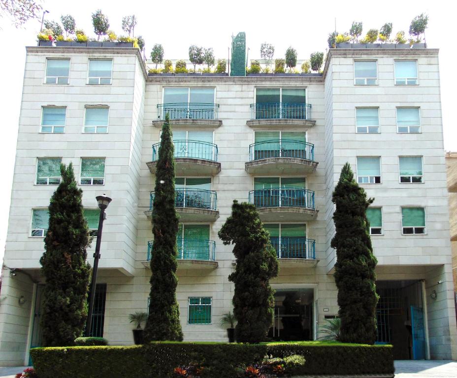 a building with trees in front of it at Residence L´ Heritage Hipólito Taine by BlueBay in Mexico City