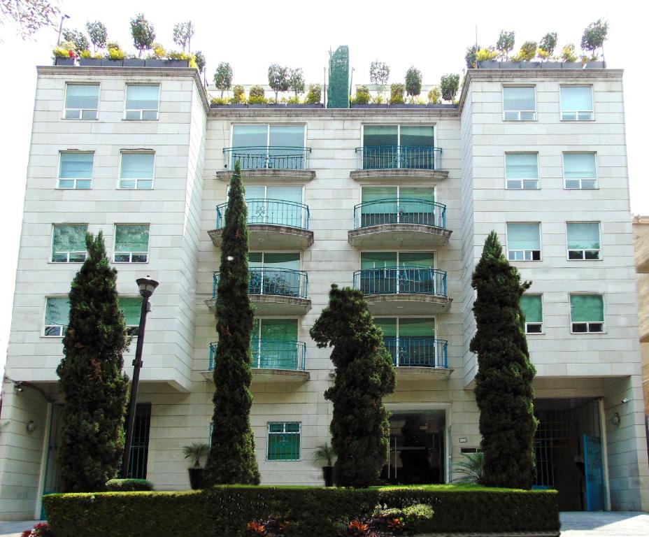 un edificio con árboles delante de él en Residence L´ Heritage Hipólito Taine by BlueBay, en Ciudad de México