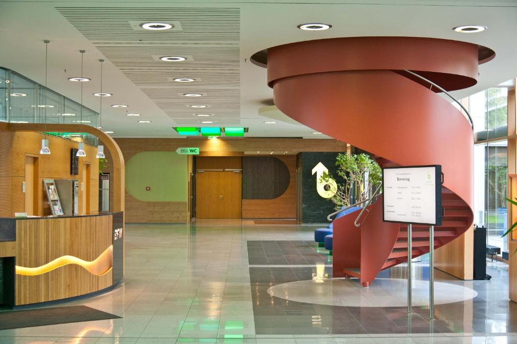 a lobby with a red staircase in a building at Hotel Bildungsblick in Kirchseeon