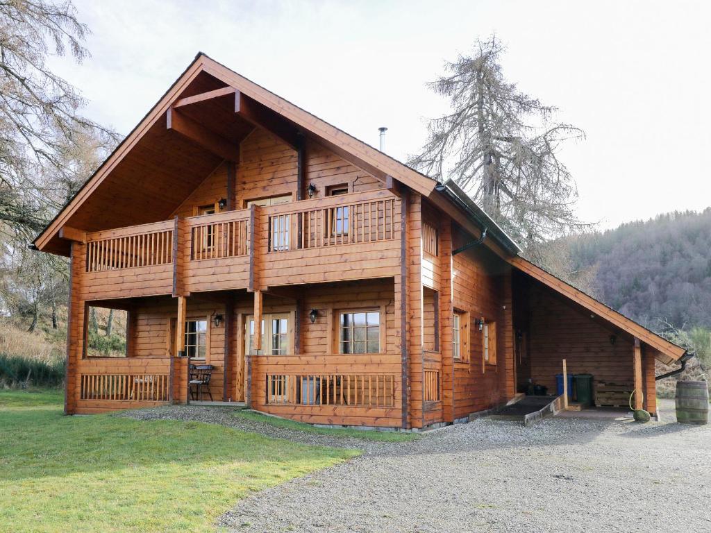 a large wooden cabin with a large porch at Allt Lodge in Inverness