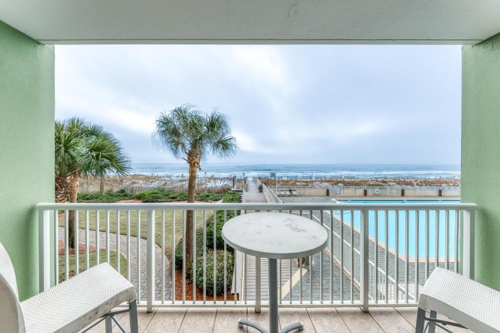 a balcony with a table and chairs and a view of the ocean at Waters Edge II in Fort Walton Beach