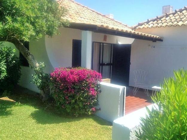 een huis met een bos met roze bloemen ervoor bij Pedras Del Rei I in Tavira