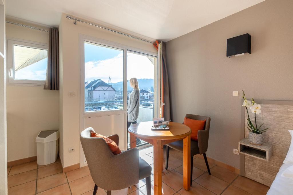 een kamer met een tafel en stoelen en een raam bij Residence Des Thermes in Lons-le-Saunier