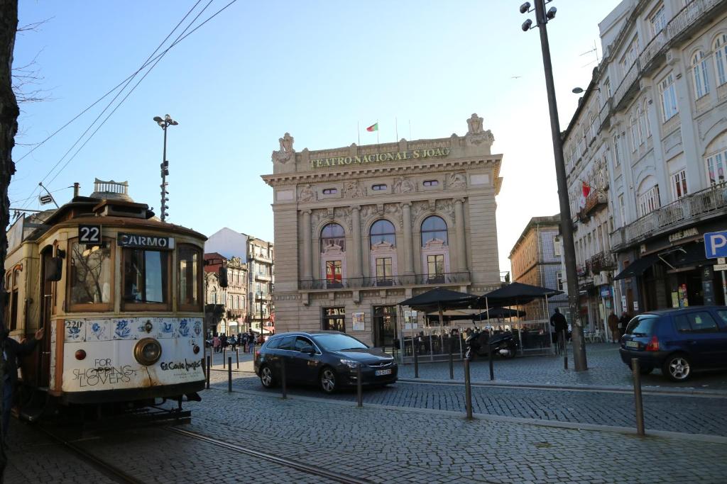 a trolley car on a city street with a building at Guest House Triunfo in Porto