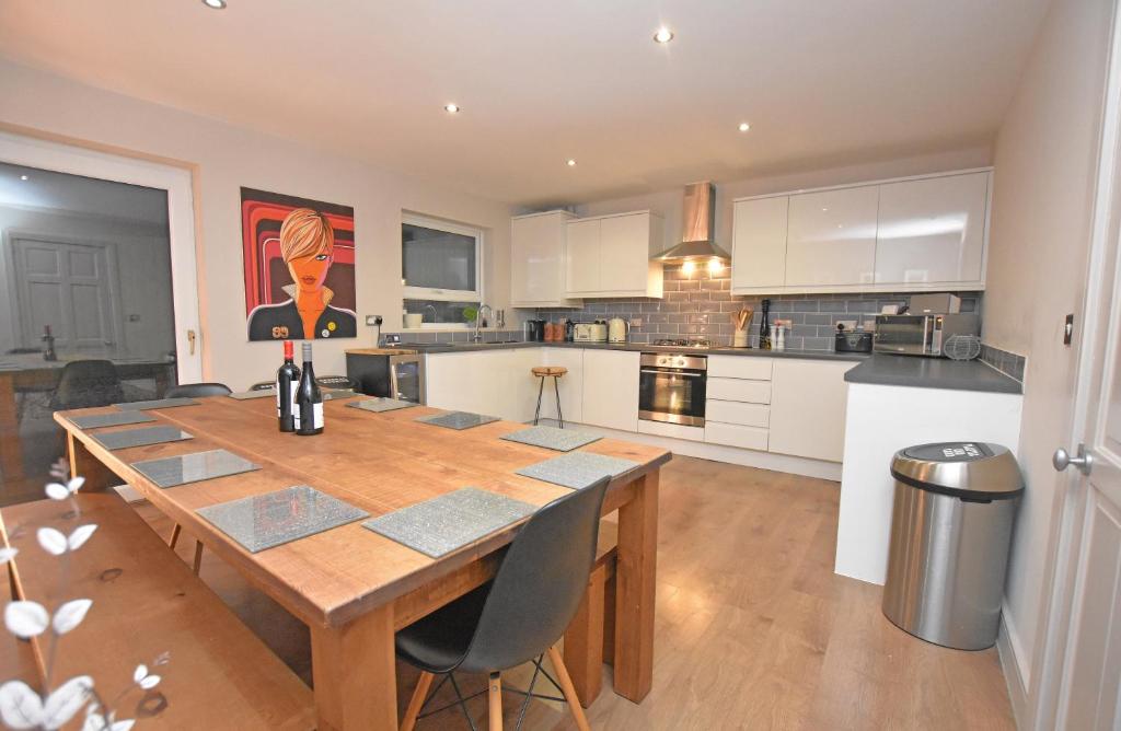 a kitchen with a wooden table and a dining room at FREE Parking, Stylish and Spacious Bungalow in Bath