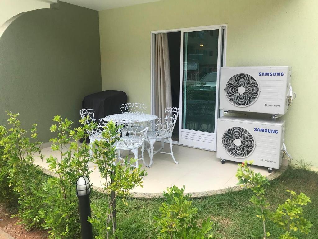 un patio con mesa y 2 aparatos de aire acondicionado en Golden lake Residence Bl3 110, en Arraial do Cabo