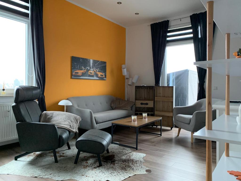 - un salon avec un canapé, des chaises et une table dans l'établissement Stadthaus Artur - Apartment Barcelona, à Remscheid