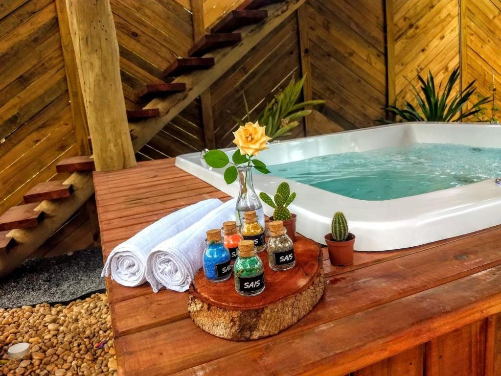 4 Elementos Guest House في ارايال دايودا: حوض استحمام مع زجاجات من البيرة على طاولة خشبية