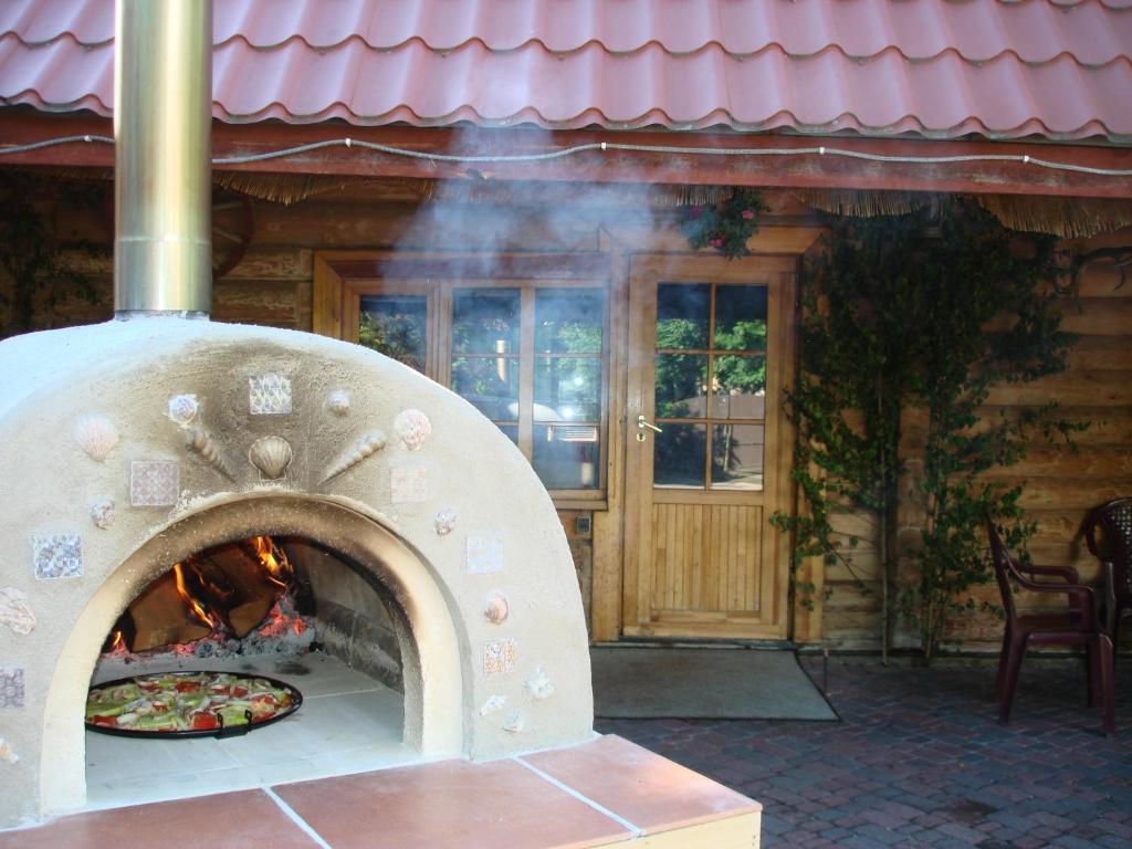 una pizza cocinando en un horno de ladrillo frente a una casa en Cozy House Mētriņi, en Ķekavas
