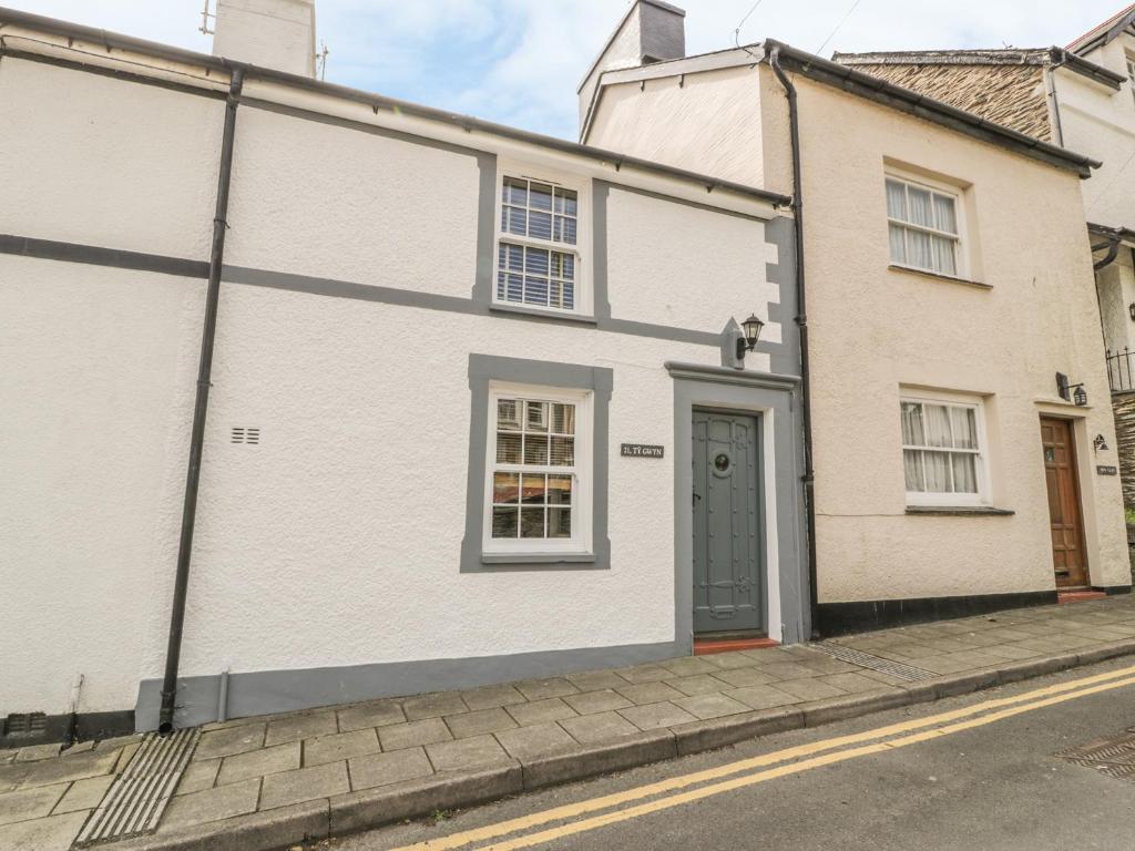 a white house with a door on a street at Ty Gwyn in Aberdyfi