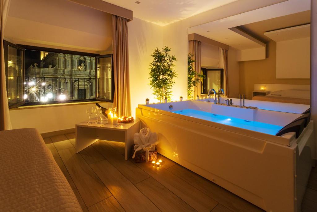 a large bathroom with a tub and a bed at Le Suites Del Duomo in Catania